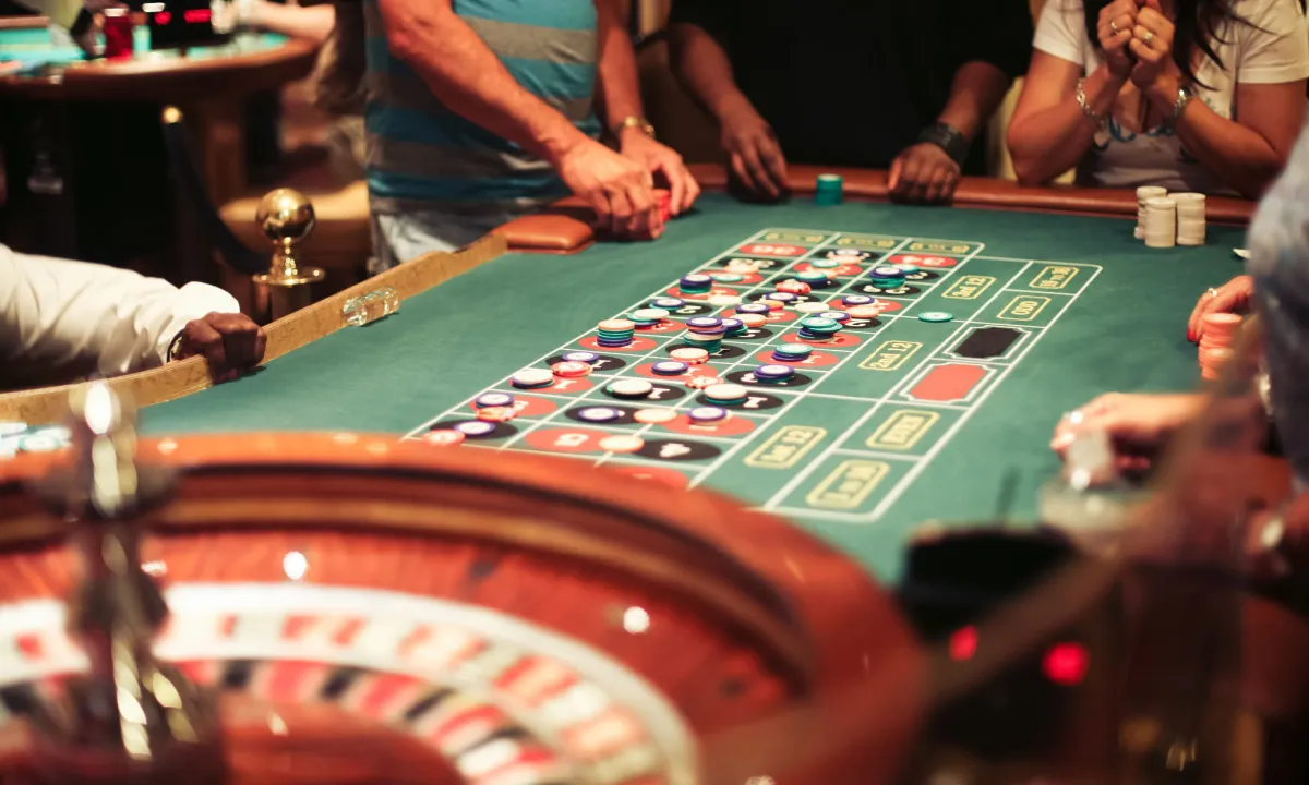 Close-up of a roulette table in a Las Vegas casino, showing the spinning wheel, betting layout, and chips.